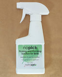 A white spray bottle labeled 'no pick Picking and Plucking Solution for Birds' with green and red text, on a beige background.